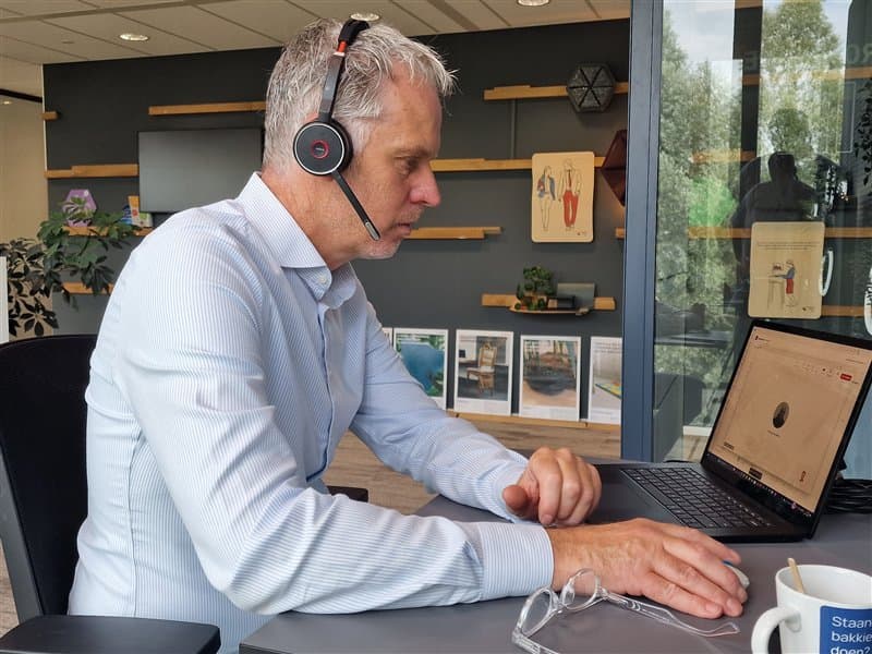 Person wearing a headset working on a laptop in an office